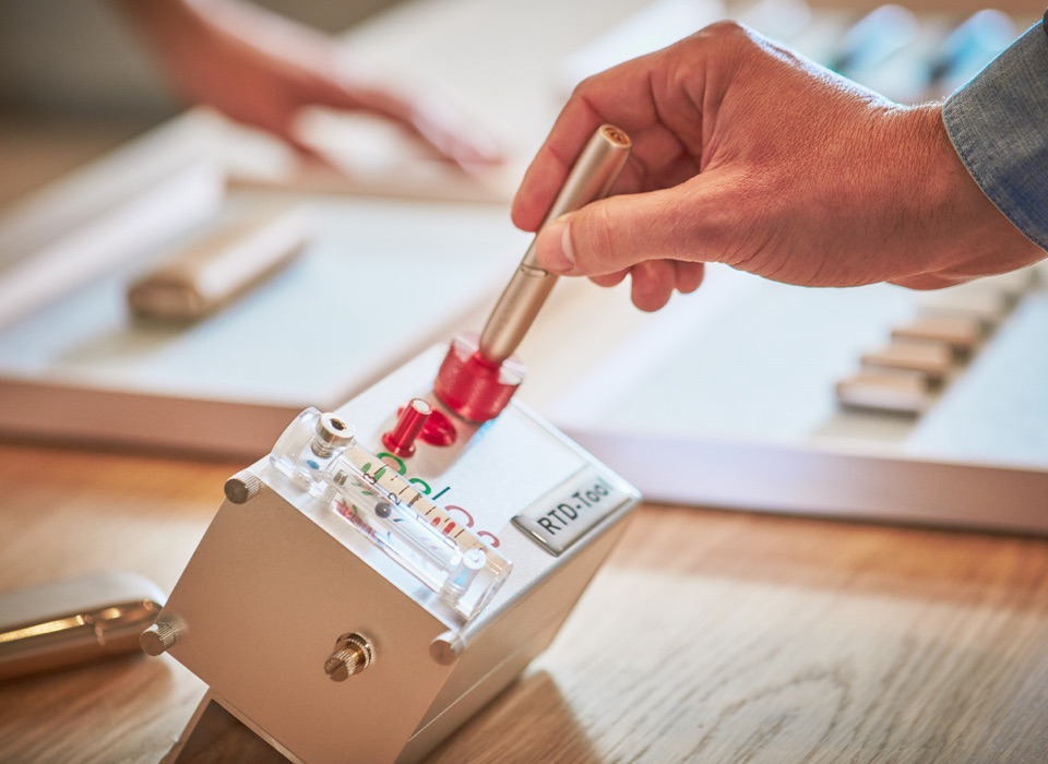 Person inserting IQOS Originals Holder into cleaning machine